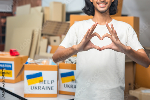 Tela Group of volunteers  asian  man and asian woman preparing food donations for people in need in Ukrain