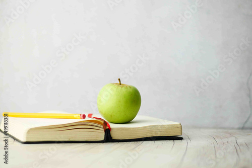 black to school concept with apple on notepad on table.