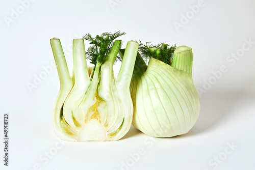 Fresh organic whole and sliced Fennel bulbs on white background.