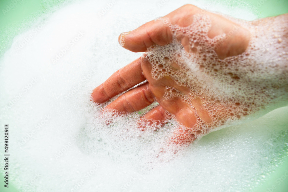 Fototapeta premium Soap foam. Foam in a green basin. Water with foam.