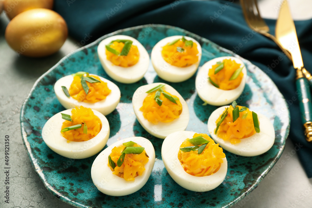 Plate with tasty stuffed eggs on grunge background, closeup. Easter celebration Plate with tasty stuffed eggs on grunge background, closeup. Easter celebration