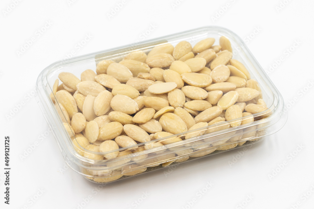 Packed peeled raw almonds on a white background. Peeled raw almonds packaged for sale at the market counter. close up Packed peeled raw almonds on a white background. Peeled raw almonds packaged for sale at the market counter. close up