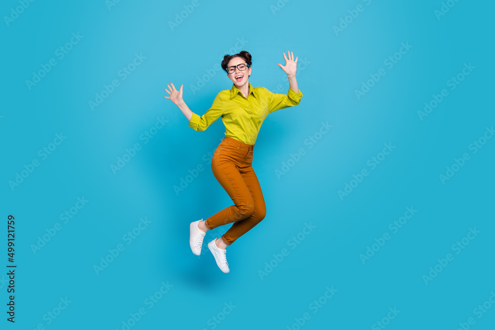 Full length photo of crazy cheerful person jumping raise arms isolated on blue color background