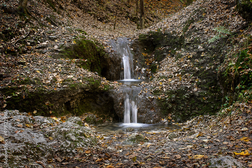 landscape with a small waterfall in an autumn forest