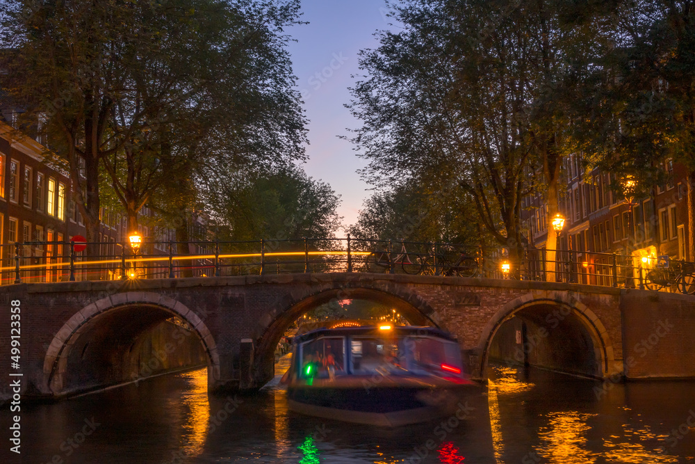 Dusk on the Amsterdam Canal and a Boat Under the Bridge