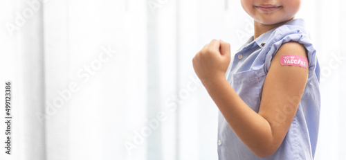 Portrait of happy smile vaccinated little asian kid boy children ages 5 to 11 years old posing show arm with medical plaster after Injection vaccine Covid-19 protection.coronavirus vaccination kid