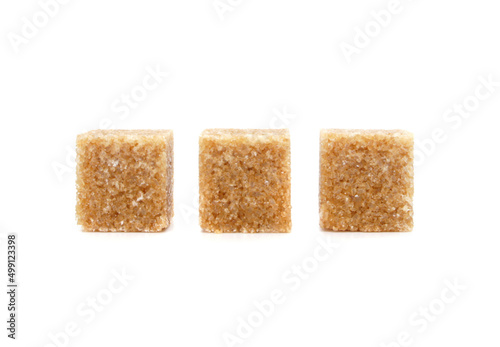 Pieces of Brown cane sugar isolated on white background. Three sugar cubes in a row.