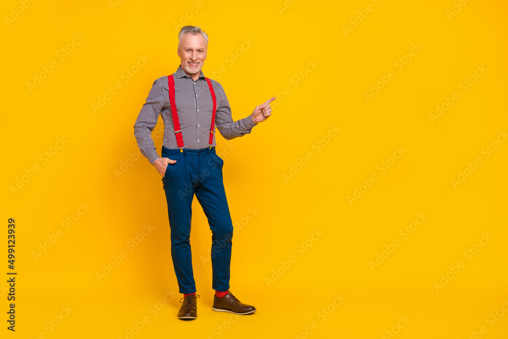 Fototapeta premium Full length body size view of attractive cheerful man demonstrating copy space isolated over bright yellow color background