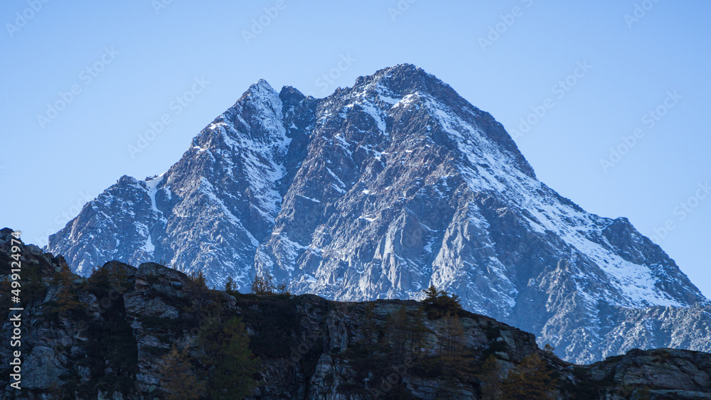 The mountains of the Lepontine Alps and the woods during a beautiful Autumn day, near the village of San Domenico di Varzo, Piedmont, Italy - October 2021.