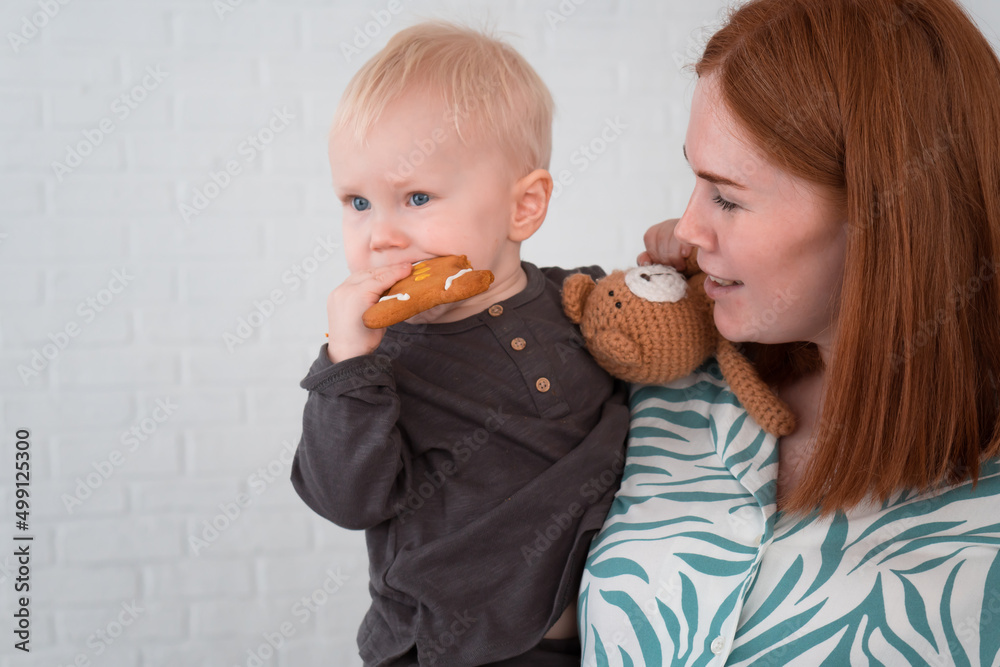 pregnant woman in pajamas holding little son in her arms