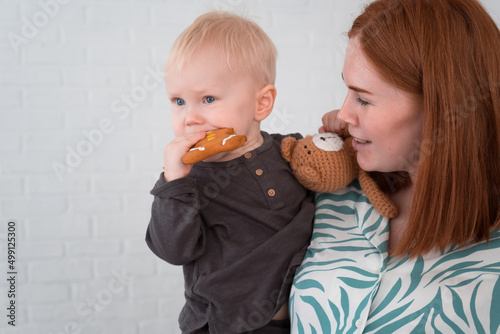 pregnant woman in pajamas holding little son in her arms
