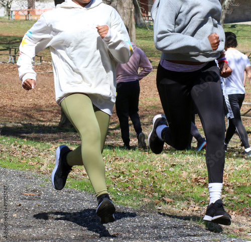 Two girls running fast uphill on a gravel path