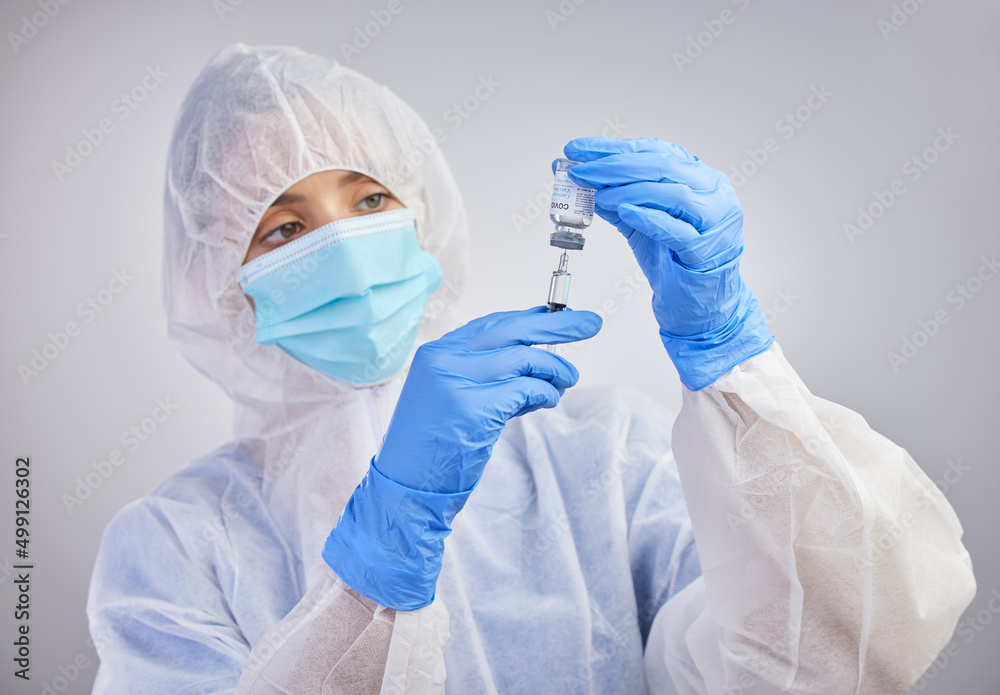 Herd immunity is possible. Shot of a nurse filling up a syringe with vaccination fluid against a studio background. Herd immunity is possible. Shot of a nurse filling up a syringe with vaccination fluid against a studio background.