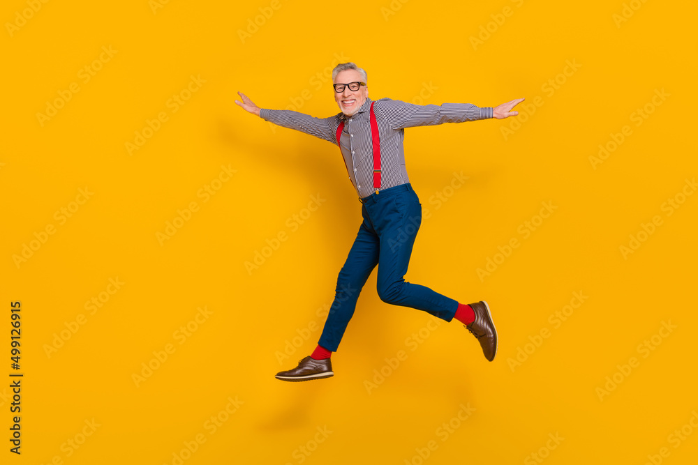 Full size profile side photo of energetic cheerful grandpa enjoy summer vacation isolated on yellow color background