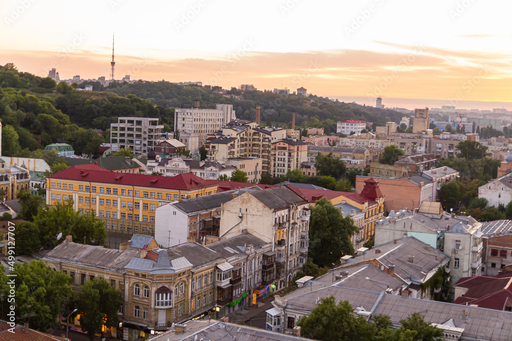 Fototapeta premium Ukraine, Kyiv – July 04, 2015: Aerial panoramic view on central and historical part, area of city Podil with residential buildings in the evening, during the sunset. Pre-revolutionary buildings