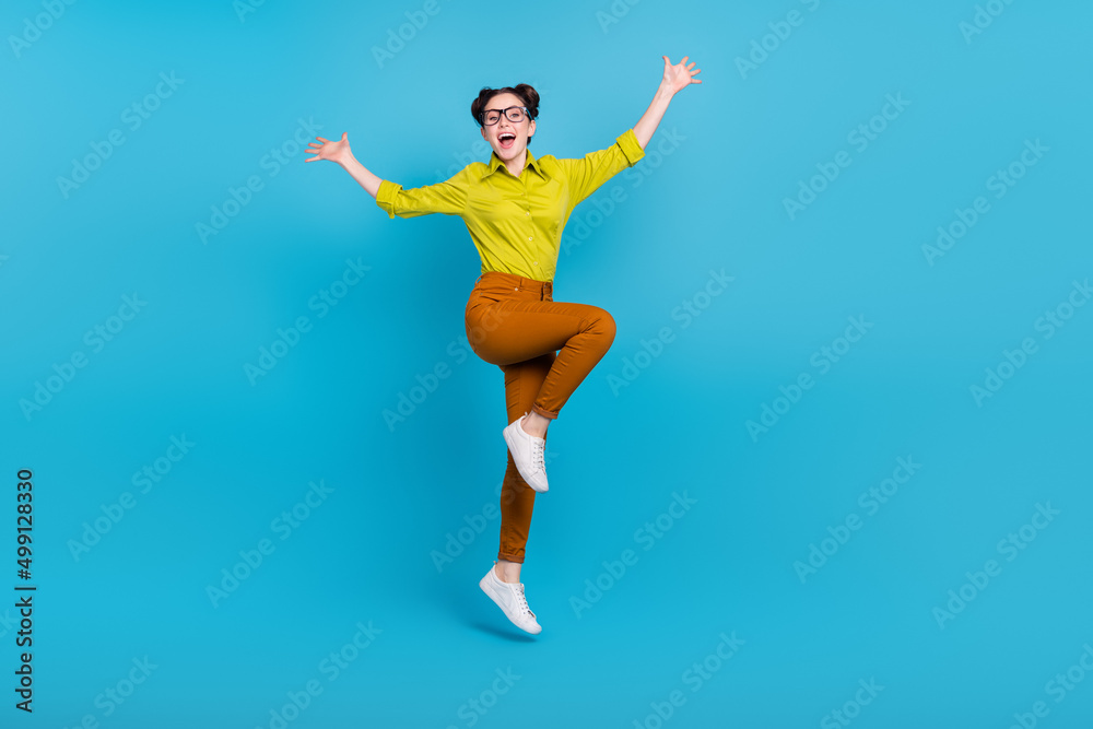 Full size portrait of active energetic girl raise hands open mouth scream isolated on blue color background