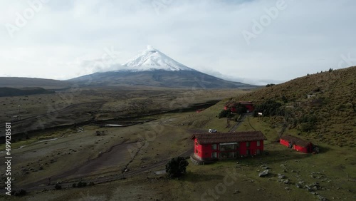 Aerial View of Red Buildings and Landscape Under Cotopaxi Volcano and Glacier, Ecuador, Drone Shot photo