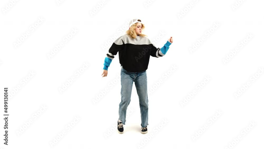 Cheerful Blonde Teenage Girl Wearing A Loose Sweatshirt And A Cap Dancing Freestyle Against White Background. - Full-Length Shot Cheerful Blonde Teenage Girl Wearing A Loose Sweatshirt And A Cap Dancing Freestyle Against White Background. - Full-Length Shot