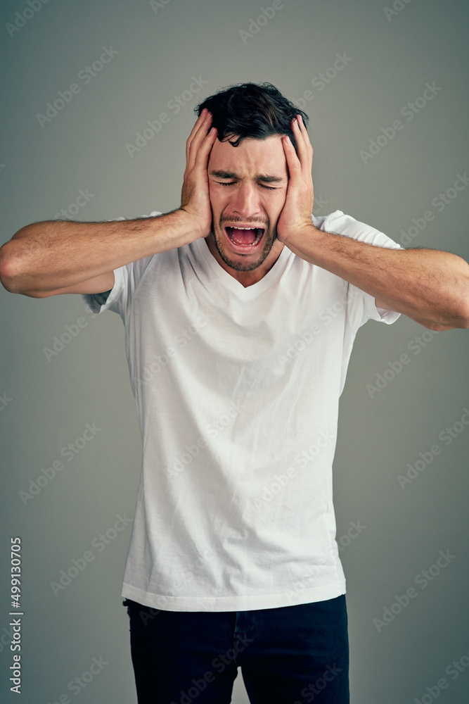 Sometimes you just need to scream. Studio shot of a casual young man posing against a grey background. Sometimes you just need to scream. Studio shot of a casual young man posing against a grey background.