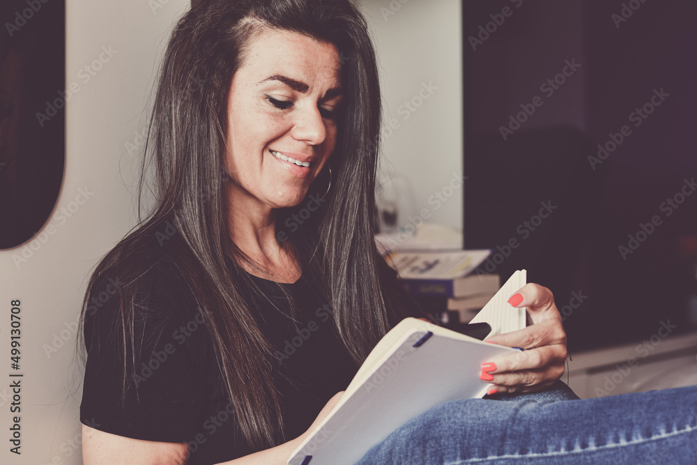 Beautiful Smiling Woman sitting on the floor at home reading a Book. Beautiful Smiling Woman sitting on the floor at home reading a Book.