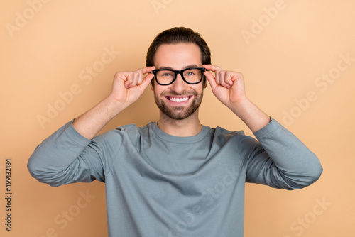 Photo of young cheerful guy wear eyeglasses clever ophthalmology isolated over beige color background