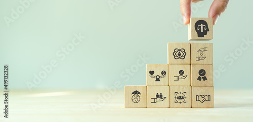 Business ethics concept. Ethics inside human mind. Business integrity and moral. Putting wooden cubes with ethics inside a head standing with other ethics icon. Company culture and sustainable success photo