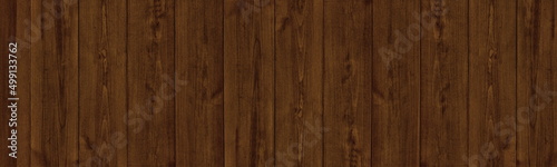 Dark brown natural shabby wooden board wide panoramic texture. Rough old wood plank rustic background