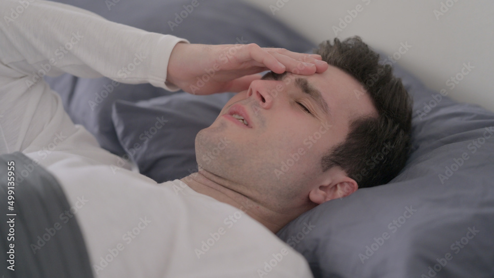 Man having Headache while Sleeping in Bed, Close up Man having Headache while Sleeping in Bed, Close up