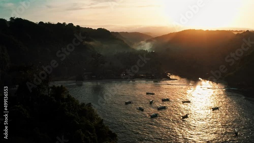 Cinematic foggy landscape coastline tropical island in the rays of the rising sun on background mountain landscape and tropical rainforest 4K Aerial view photo