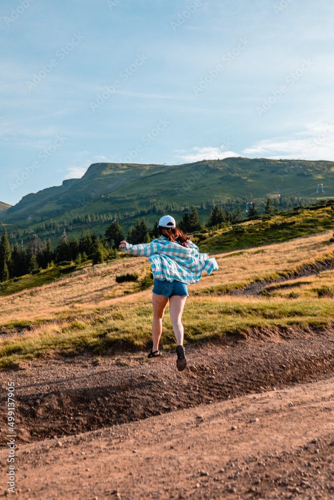 Naklejka premium woman enjoying sunset above the mountains