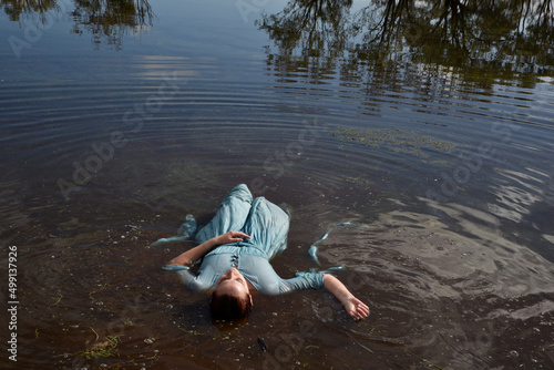 Portrait of beautiful girl wearing flowing  fantasy gown in a magical lake background. photo