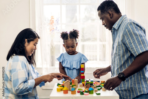 Portrait of happy love black family african american father and mother with little girl smiling activity learn and skill brain training play with toy build wooden blocks board education game at home