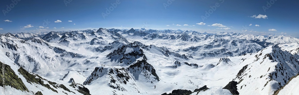 Fototapeta premium Large mountain panorama on the Gorihorn Isentallispitz with a view of many mountain peaks in Davos Klosters. Ski touring in winter.
