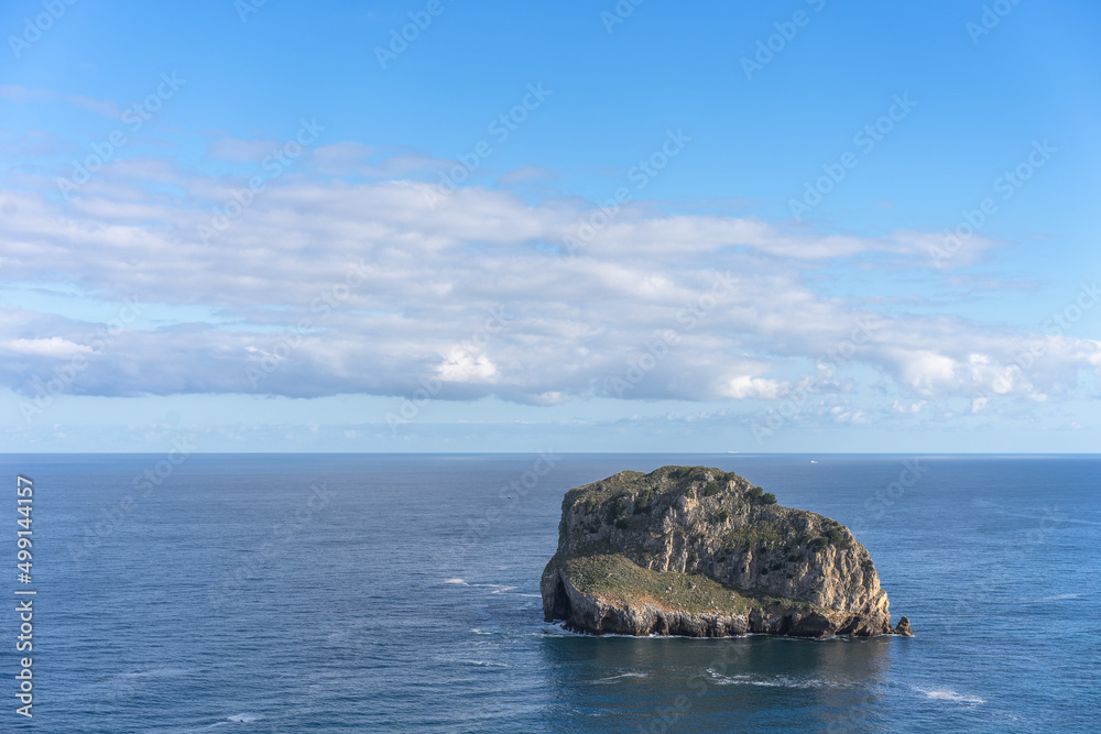 Empty islet in the middle of the sea with cloudy sky Empty islet in the middle of the sea with cloudy sky