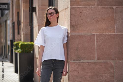 Woman in white blank t-shirt wearing glasses in the city