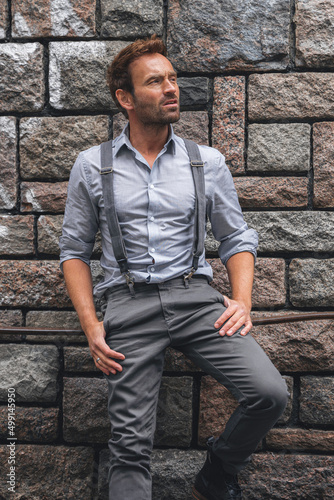 Portrait of an attractive male modeling infront of a grey stone wall