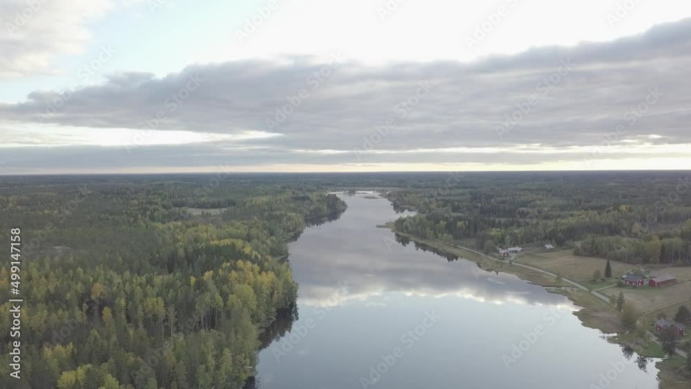 Aerial backwards view of forest along the river. Reflections of clouds. Finland Aerial backwards view of forest along the river. Reflections of clouds. Finland