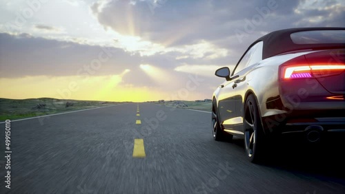 Black car driving on an asphalt highway. Beautiful sunset landscape. Road trip in a sun rays on horizon. 