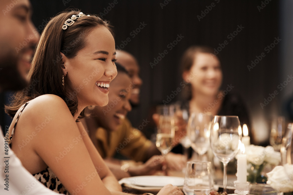 I couldnt have asked for better company. Shot of an attractive young woman sitting and enjoying a New Years dinner party with friends.
