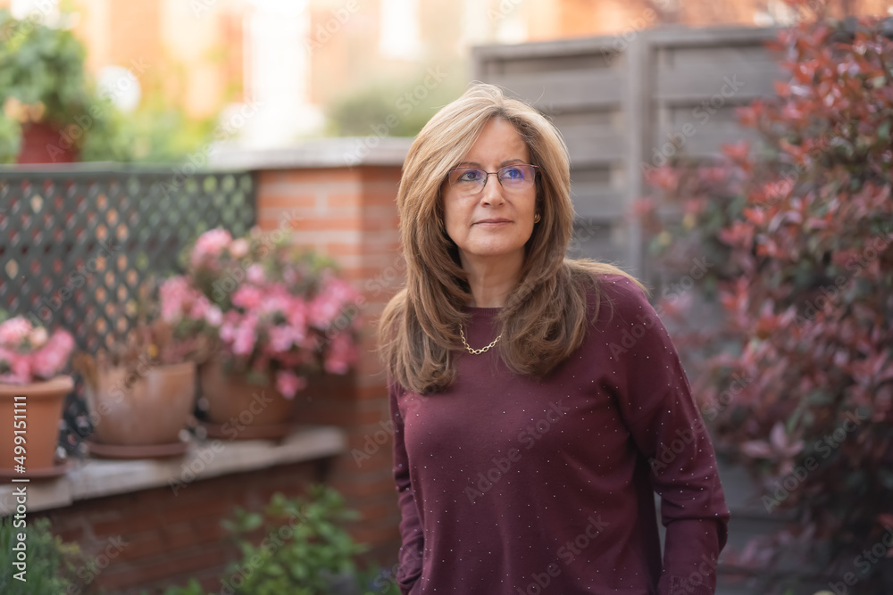 Mature white woman in the garden with flashes of the sun on her back. Mature white woman in the garden with flashes of the sun on her back.