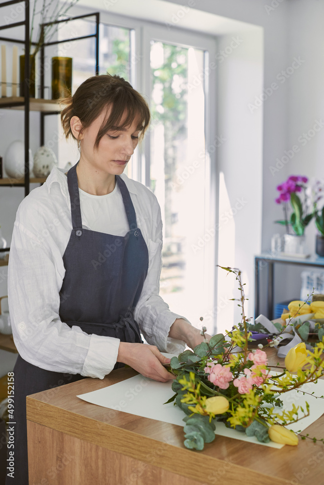 beautiful young florist makes a bouquet beautiful young florist makes a bouquet
