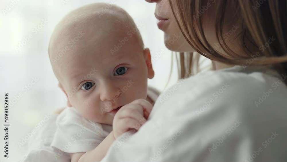 Young woman embracing and talking to her newborn son Young woman embracing and talking to her newborn son