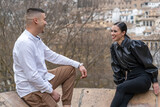 Two stylish young people chatting and laughing outdoors