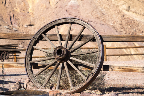 Obraz na plátně Old wagon wheel leaning on a fence