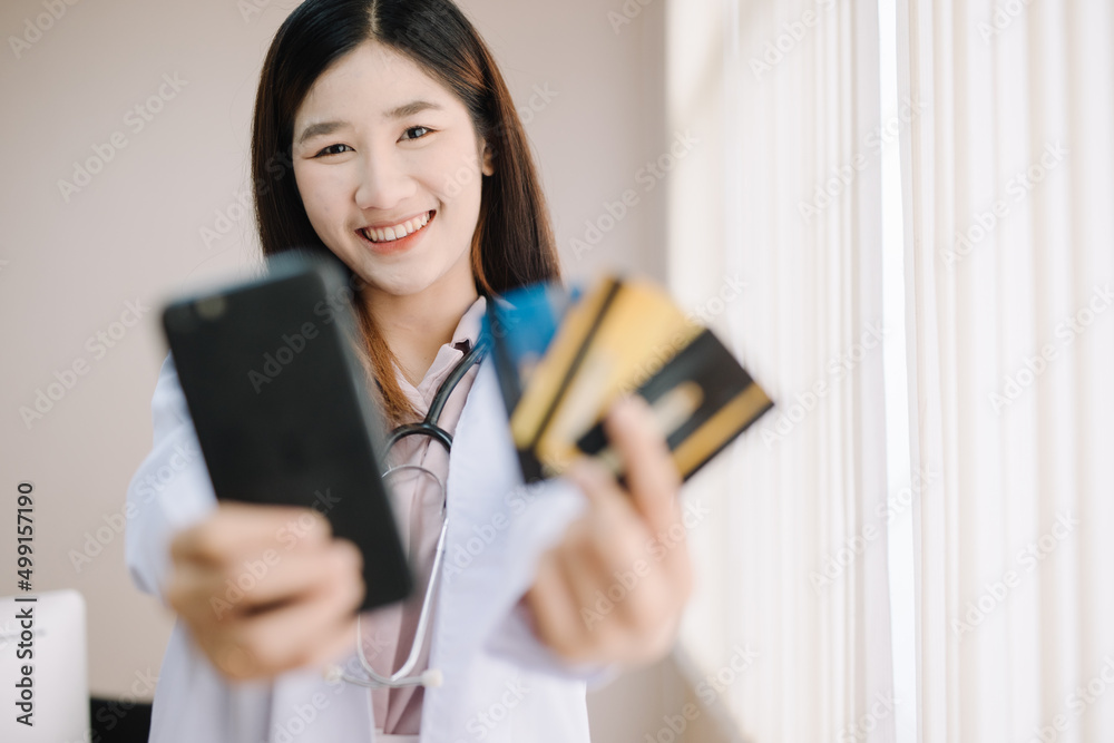 Doctor is doing financial transactions by smartphone and credit card mockup. ,Convenience concept of payment with technology Doctor is doing financial transactions by smartphone and credit card mockup. ,Convenience concept of payment with technology
