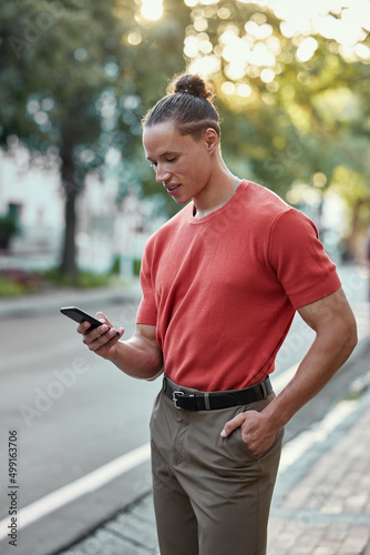 Meet me in the city. Shot of a young man using his phone in the city.