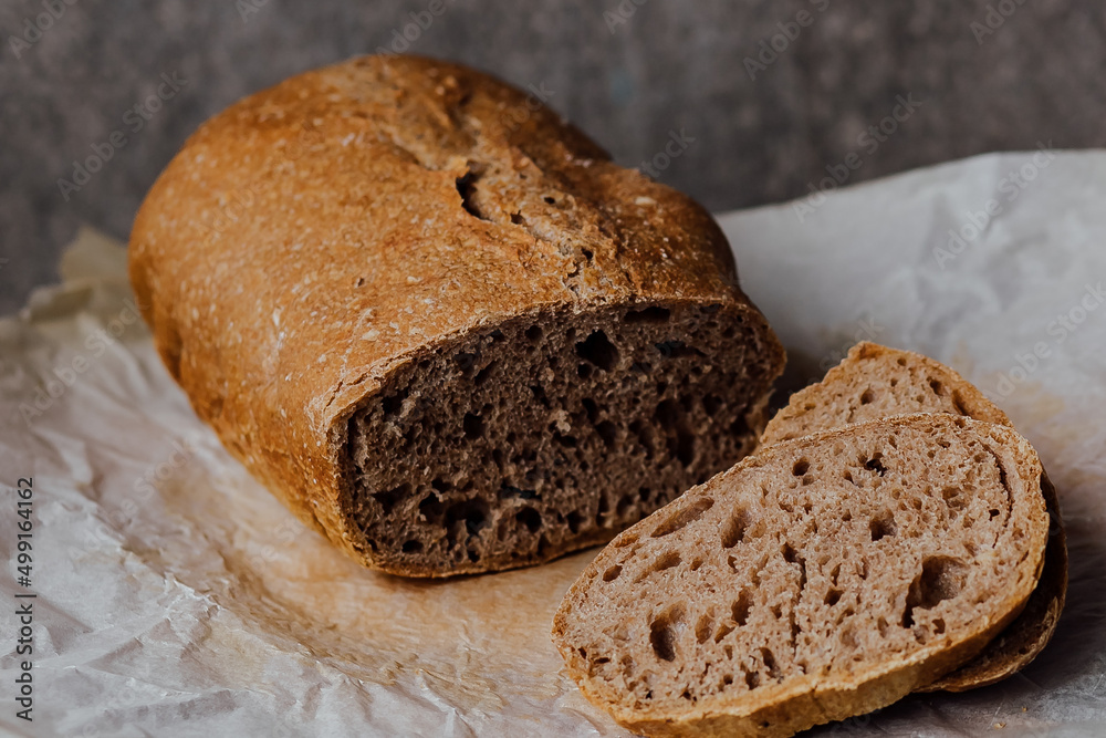 Bread, traditional sourdough bread cut into slices on a rustic wooden background. Concept of traditional leavened bread baking methods. Healthy food. Bread, traditional sourdough bread cut into slices on a rustic wooden background. Concept of traditional leavened bread baking methods. Healthy food.