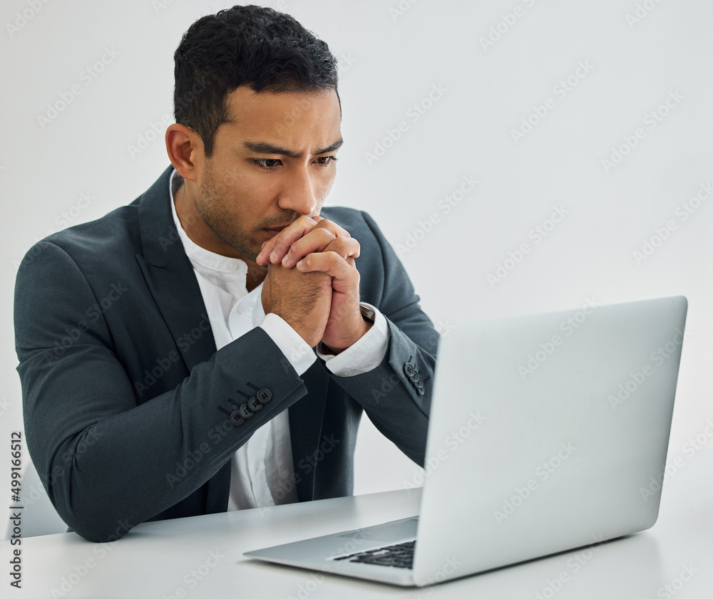 The main thing, frozen but ageing. Shot of a businessman looking worried while using his laptop at his desk in a modern office. The main thing, frozen but ageing. Shot of a businessman looking worried while using his laptop at his desk in a modern office.
