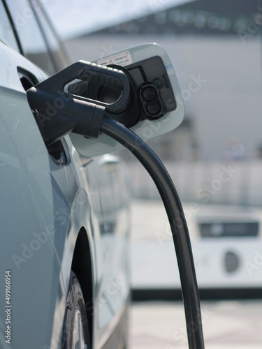 Vertical photo of an electric vehicle charging at a charging station