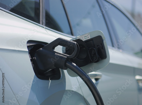 Close-up photo of an electric vehicle charging at a charging station